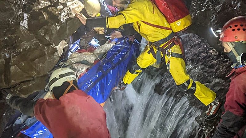 Rescuers stretcher the caver through the system. Photo: SMWCRT