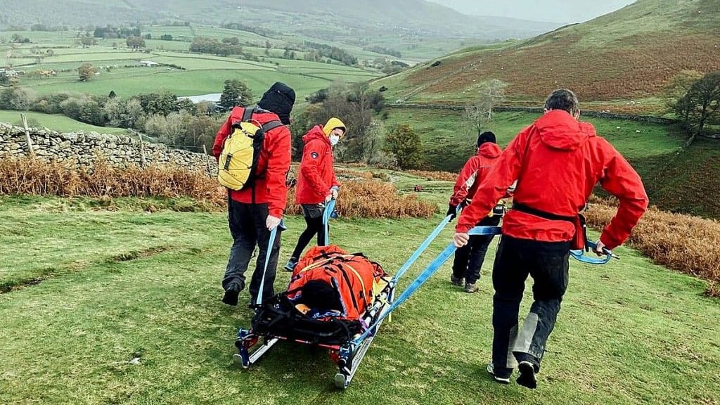 Rescuers stretcher the walker from the fell. Photo: Keswick MRT