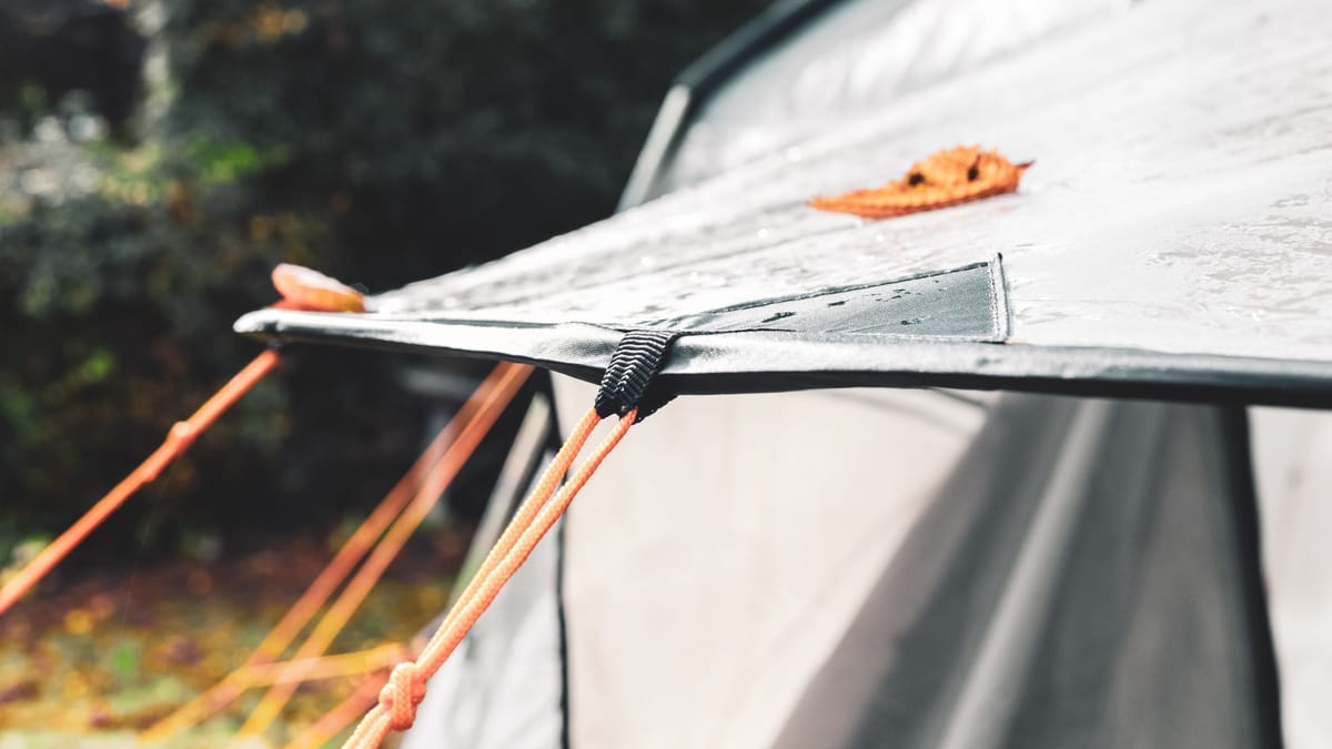 A tent pitched in wet autumn weather outdoors for a staycation camping trip